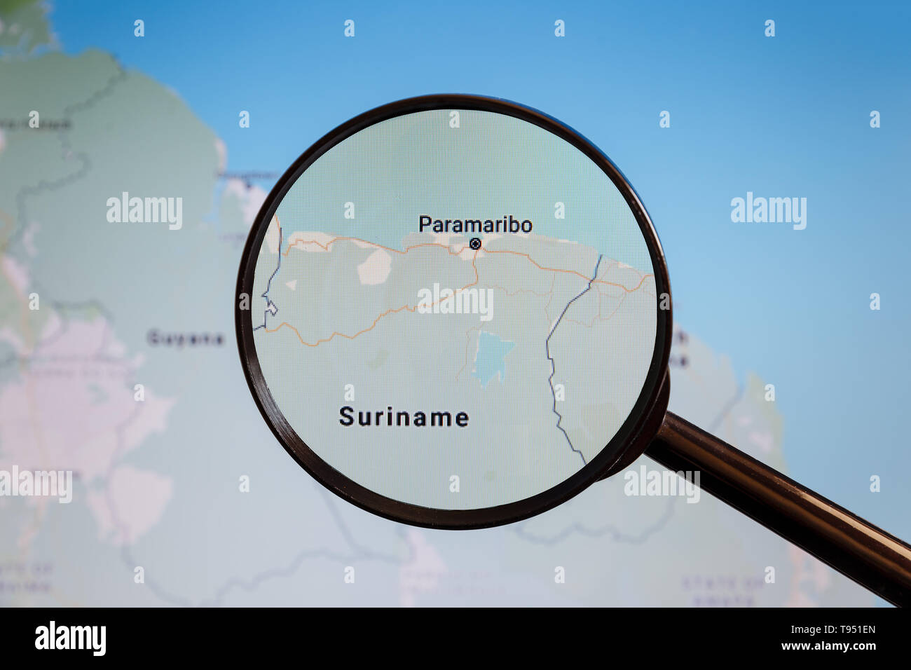 En Paramaribo, Suriname. Mapa político. La ciudad en la pantalla del monitor a través de una lupa. Foto de stock