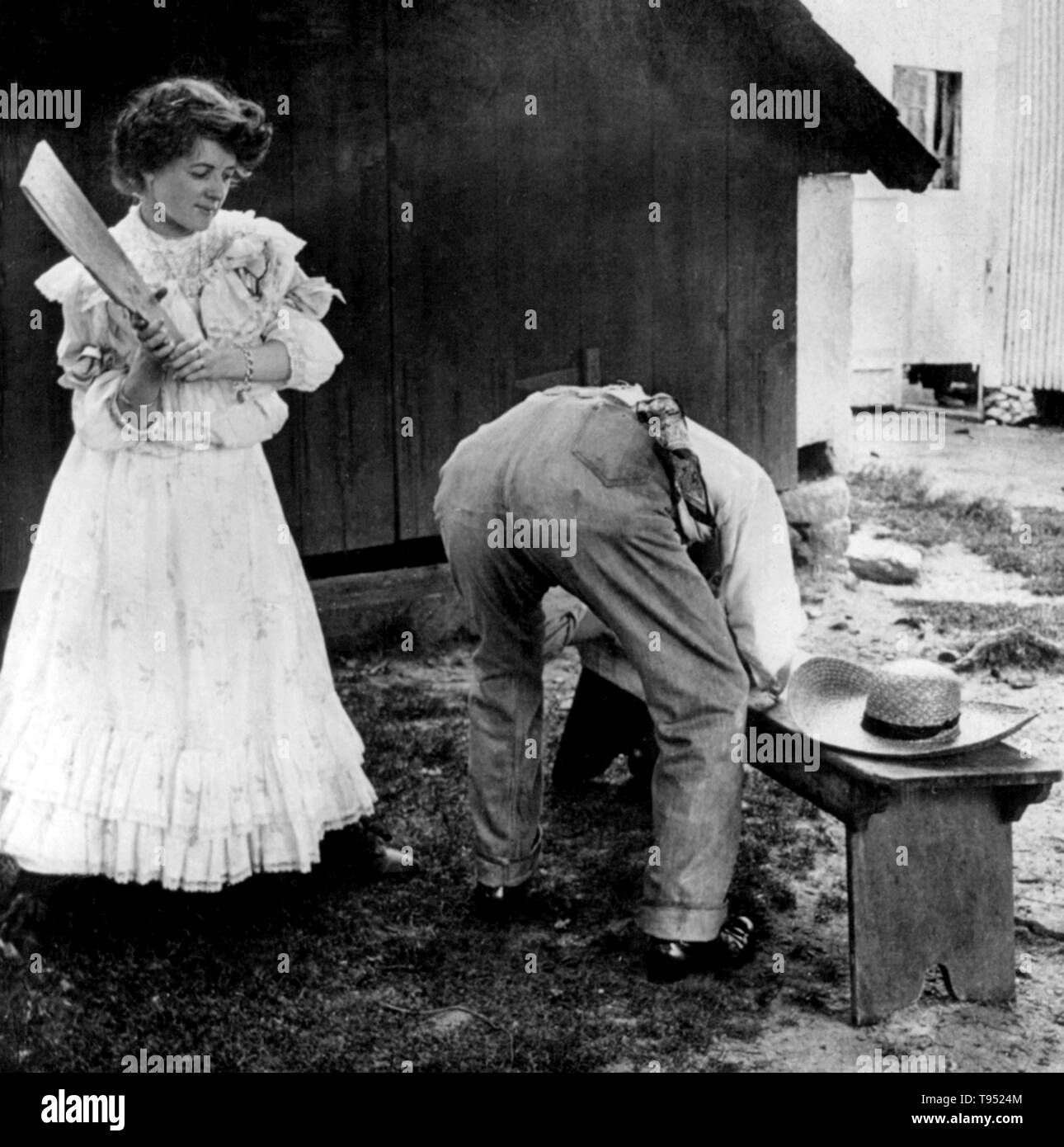 Titulado: "Una inesperada reunión de la junta' muestra a una mujer por golpear a un hombre con un consejo." recortado stereograph fotografiado por E.W. Kelley, 1906. Foto de stock