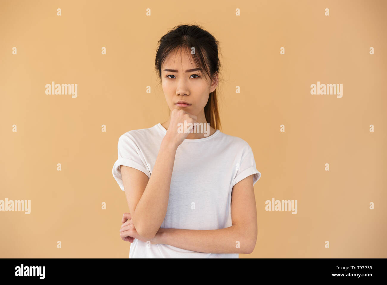 Retrato de mujer asiática obused vestían camiseta básica posando en cámara  con cara de enojado aislado sobre fondo beige en studio Fotografía de stock  - Alamy