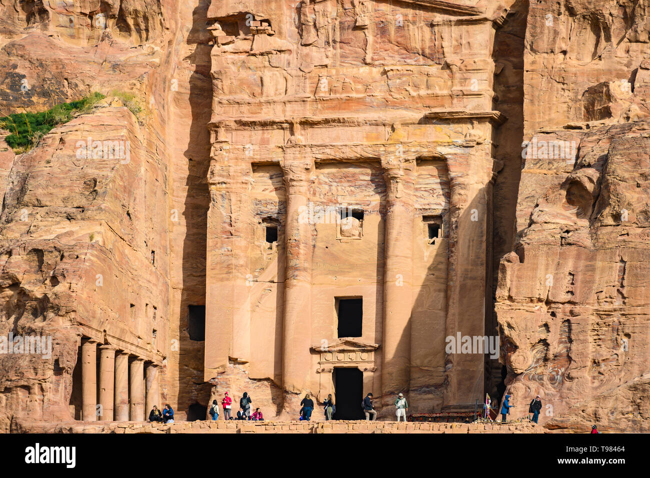 Algunos turistas se admira y tomar fotografías de un inmenso templo tallado en la roca. Foto de stock