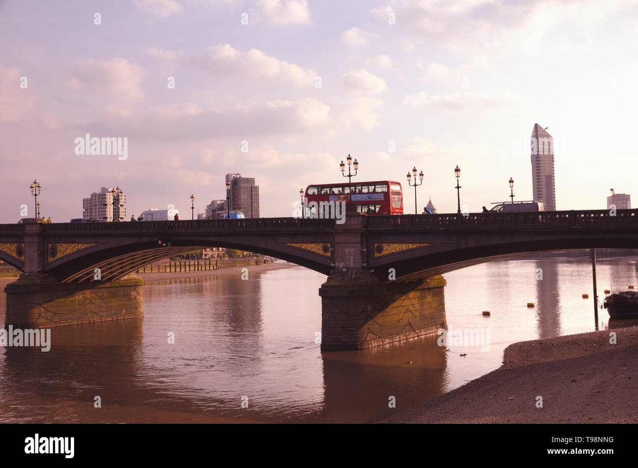 Un autobús de dos pisos rojo en Battersea puente que cruza el río Támesis, Chelsea Embankment, Londres, Inglaterra, Reino Unido. Foto de stock