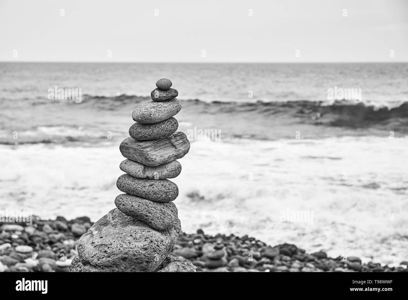 Fotografía en blanco y negro de una pila de piedra en una playa, el enfoque selectivo. Foto de stock