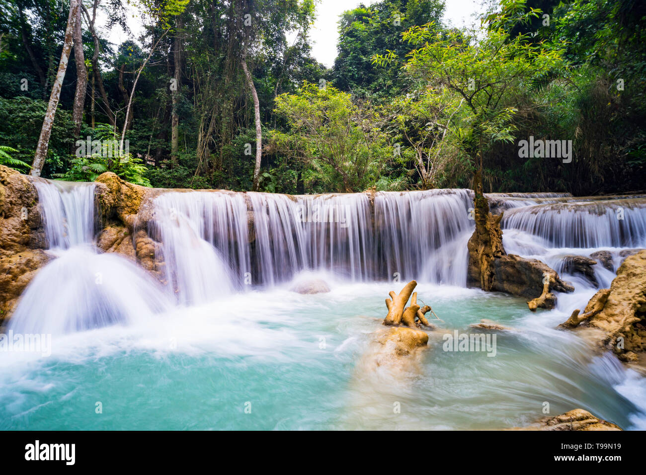 La cascada y pequeño estanque fresco con agua de color turquesa. Concepto de turismo ecológico. Fantásticamente hermosa naturaleza con agua clara y salvajes bosques Foto de stock