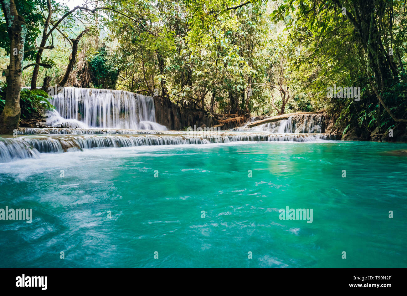 La cascada y pequeño estanque fresco con agua de color turquesa. Concepto de turismo ecológico. Fantásticamente hermosa naturaleza con agua clara y salvajes bosques Foto de stock