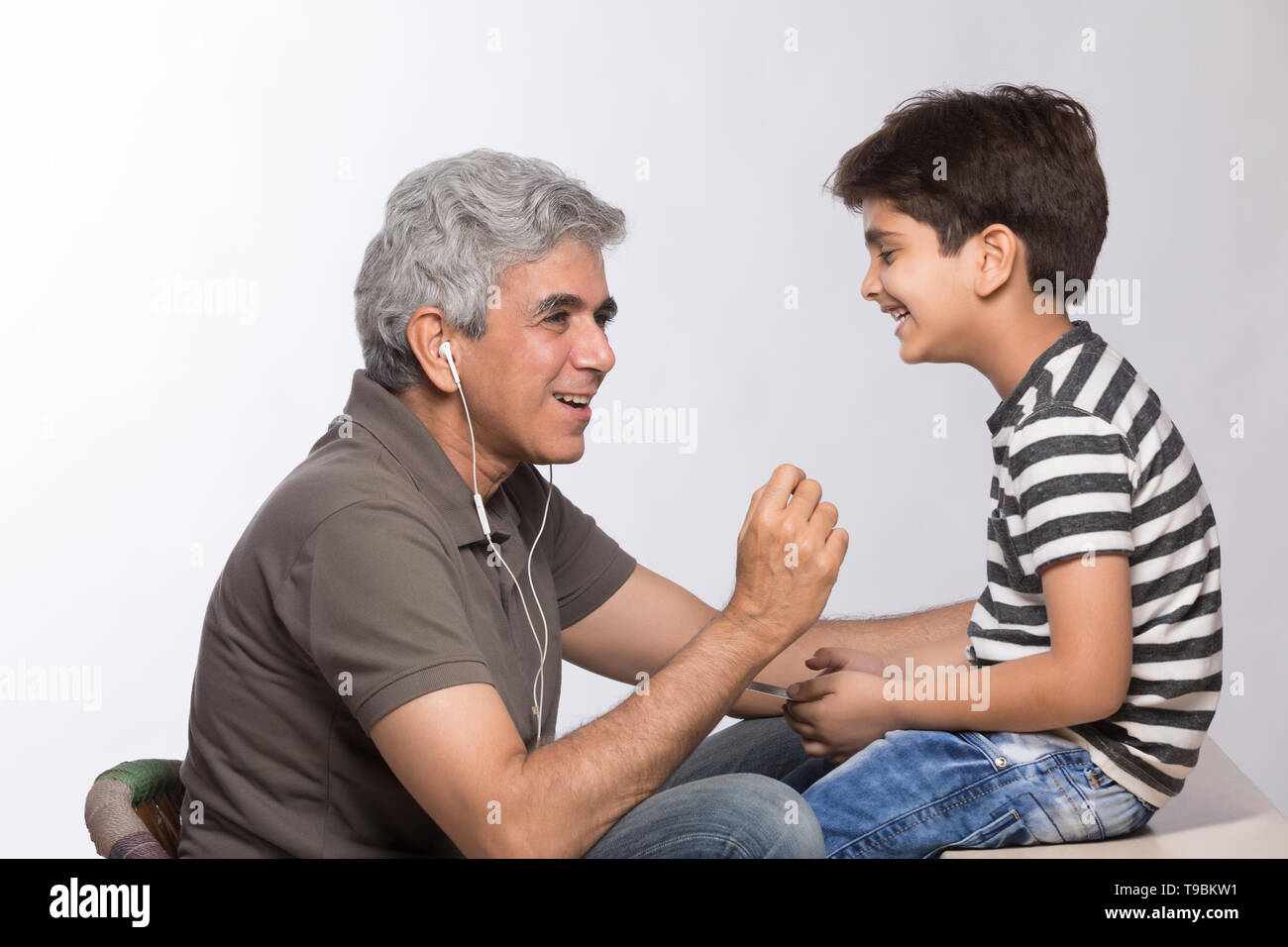 Abuelo y nieto de escuchar música con auriculares. Foto de stock