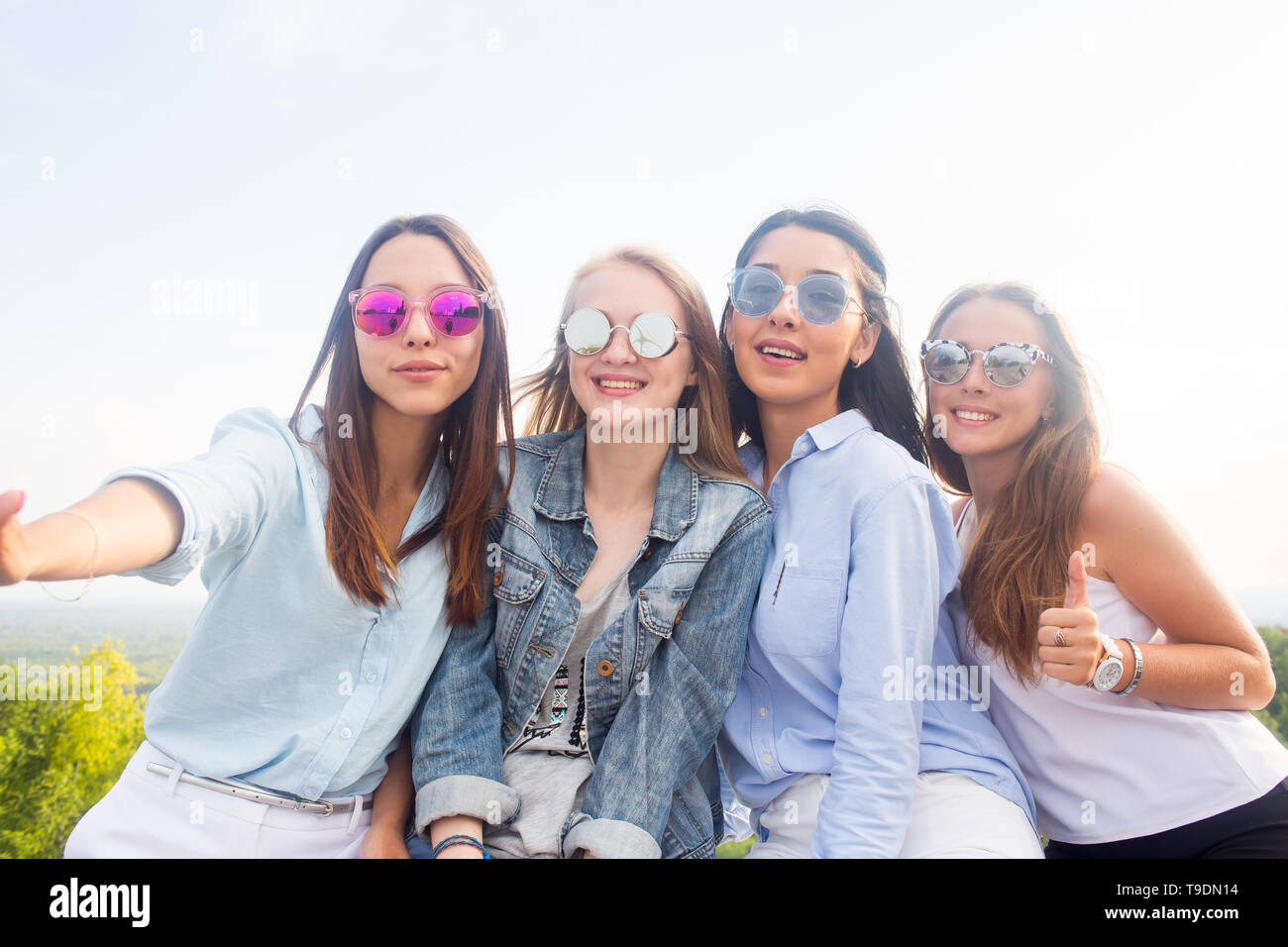 Mejores amigos tomar selfies mientras camina por el parque. Cuatro hermosas  mujeres con gafas de sol están teniendo un buen día. Cuatro hermosas chicas  jóvenes estudiantes Fotografía de stock - Alamy