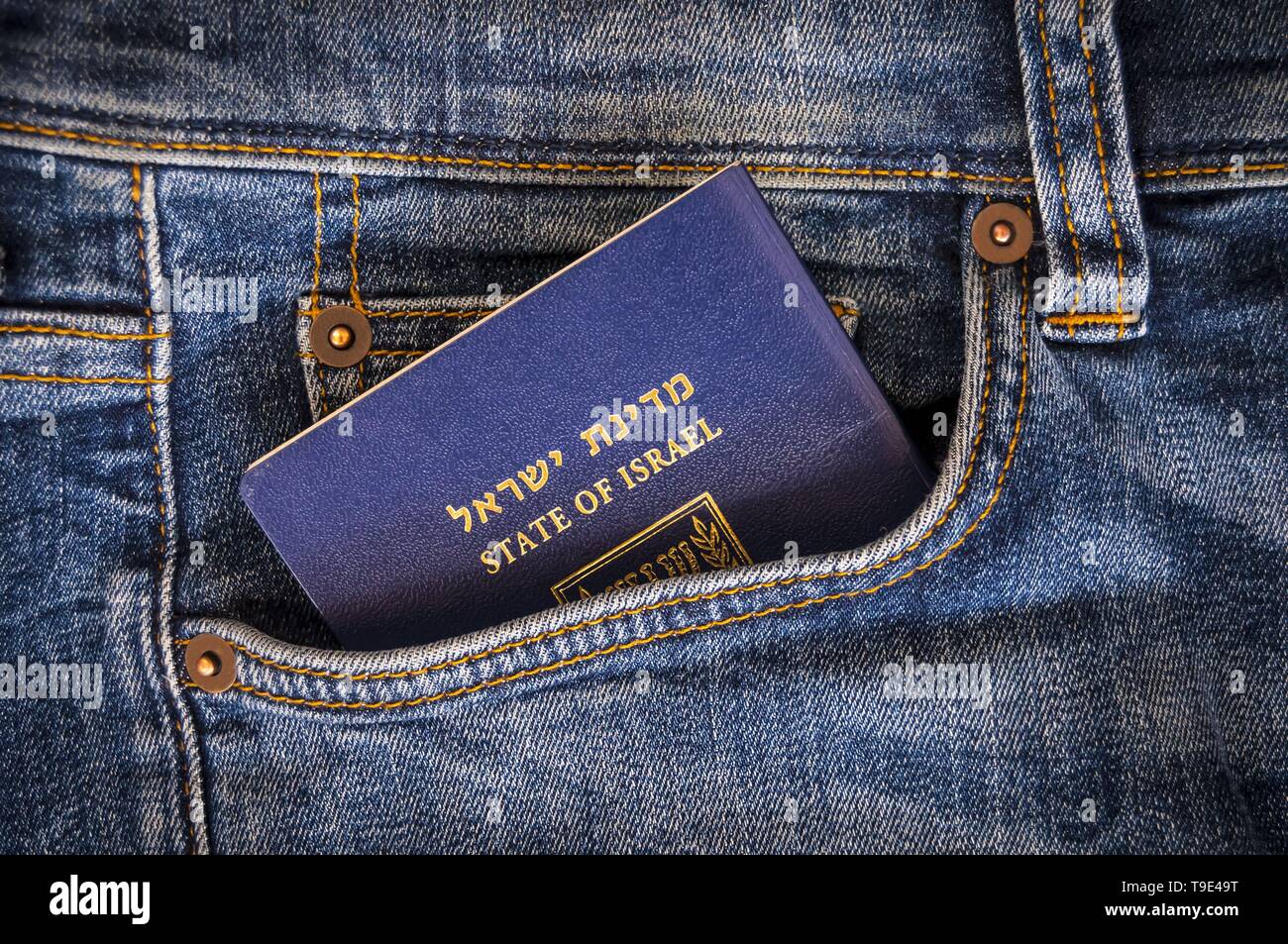 Un pasaporte azul del Estado de Israel, sobresaliendo de un bolsillo de los pantalones vaqueros azules. Los viajes de turismo israelí, Israel ciudadanía, biométricos israelí Foto de stock