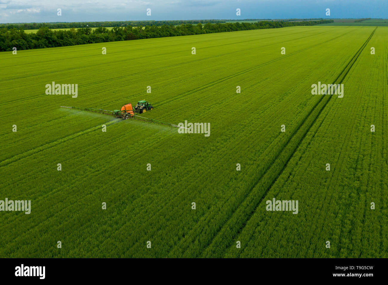 Rusia, Gaymanovskaya - Mayo 12, 2019: Un tractor en el campo. La agricultura moderna. El uso de las nuevas tecnologías en la agricultura. Vista aérea. Foto de stock