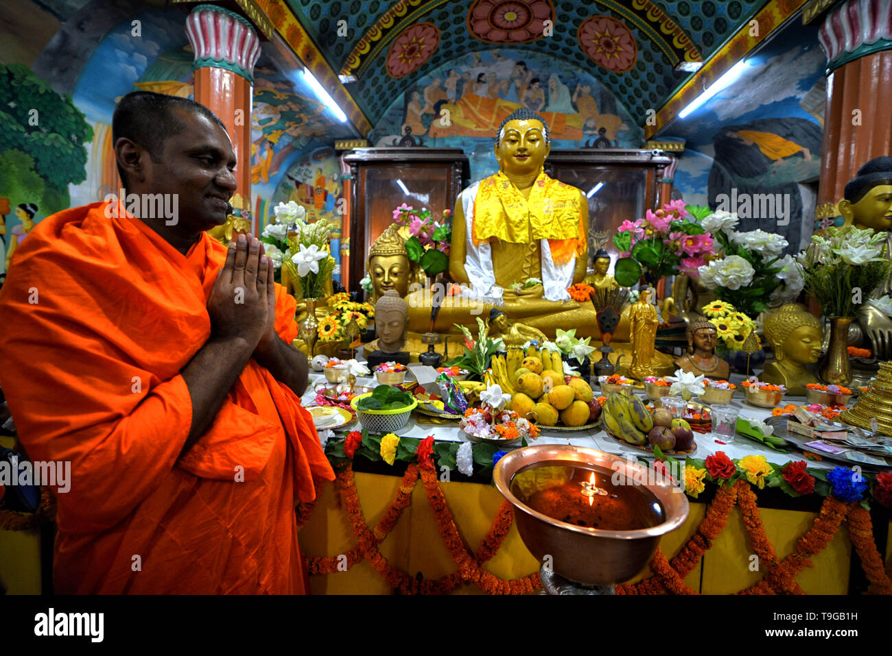 Un monje budista visto orar delante de una estatua de Buda durante el  Buddha Purnima oraciones. Cumpleaños de buda es una fiesta que  tradicionalmente se celebra en la mayoría de los países