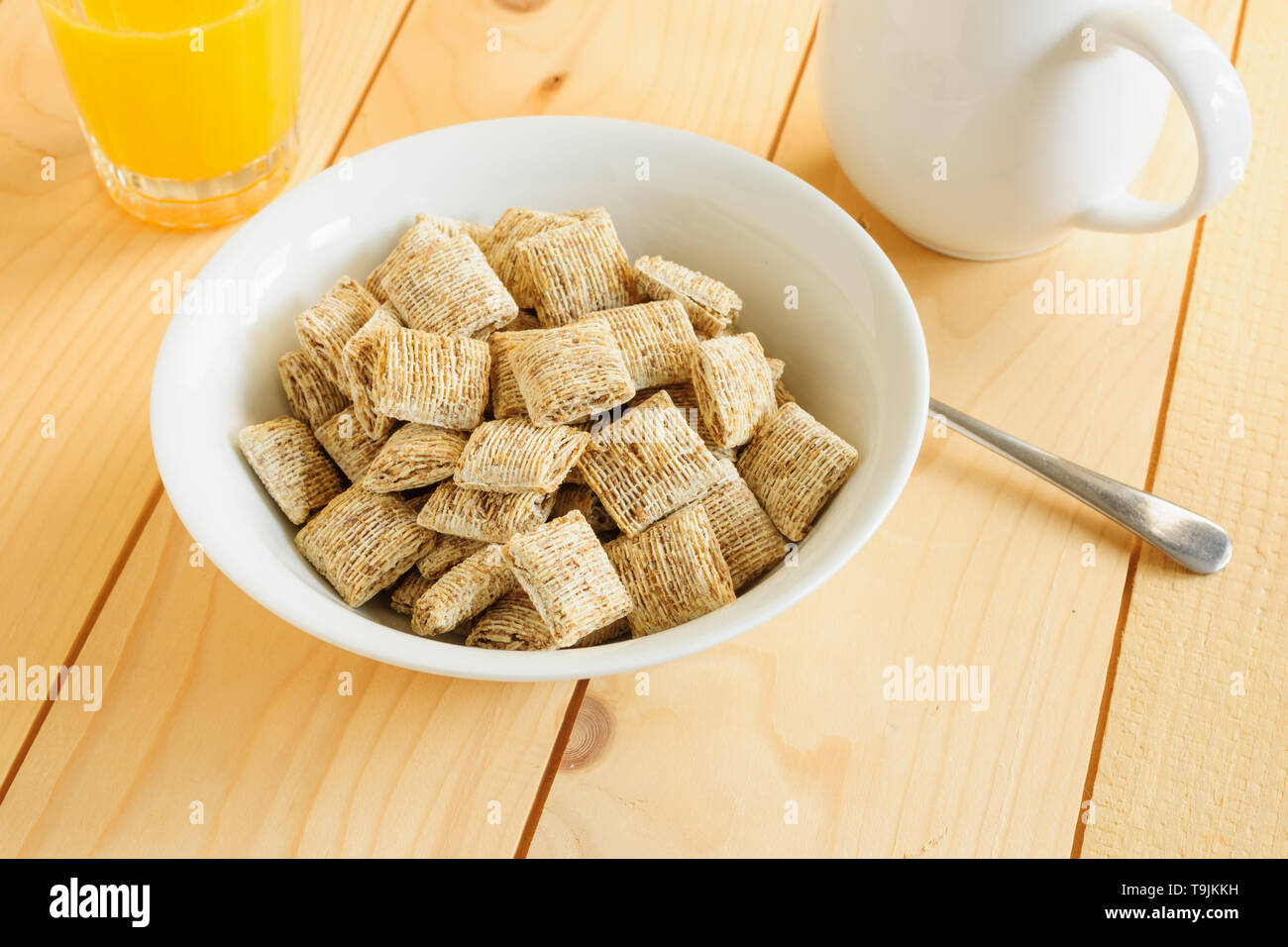 Tamaño bocado saludable trigo entero el cereal de desayuno galletas de alto contenido en fibra dietética con jugo de naranja Foto de stock