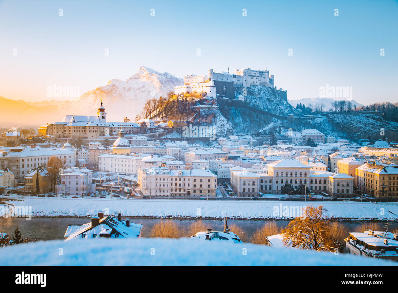Vista clásica de la histórica ciudad de Salzburgo con la famosa fortaleza de Hohensalzburg y el río Salzach y pintorescas en la luz de la mañana al amanecer en un hermoso c Foto de stock
