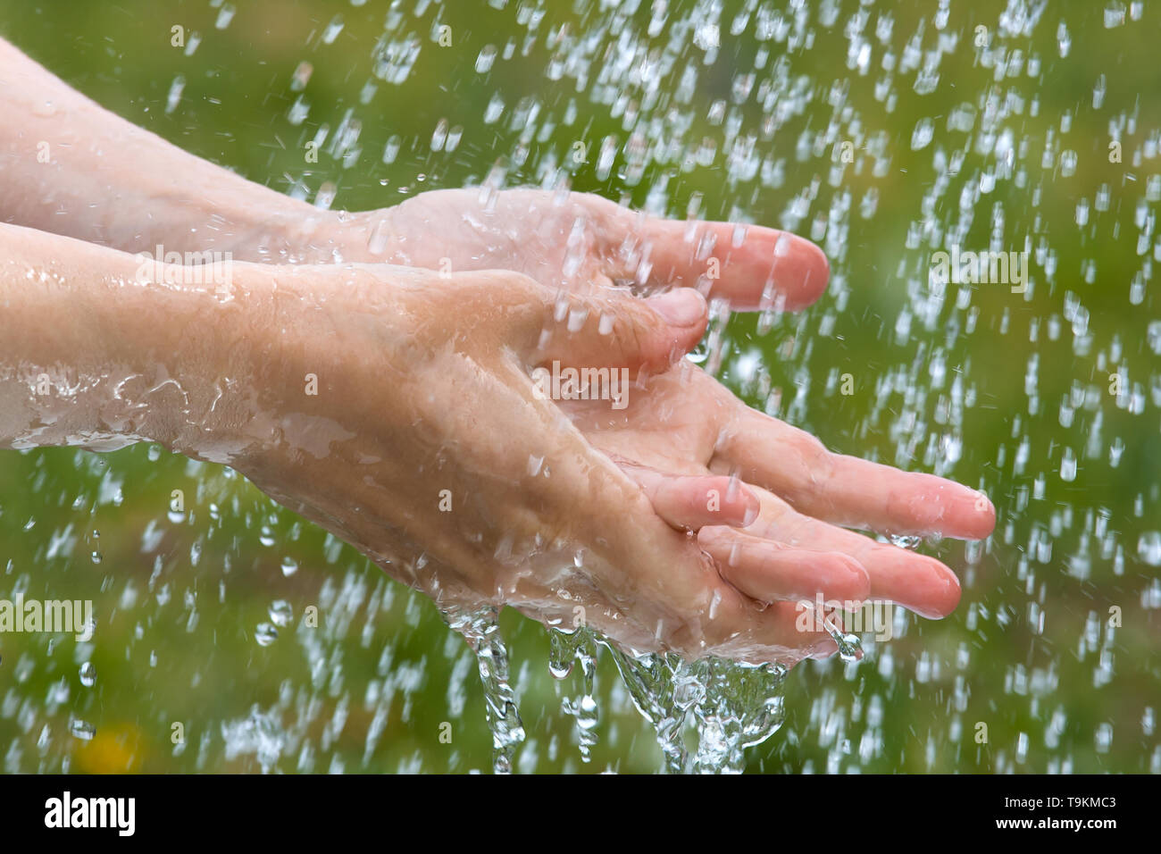 Mujer lava sus manos bajo la lluvia, closeup Fotografía de stock - Alamy