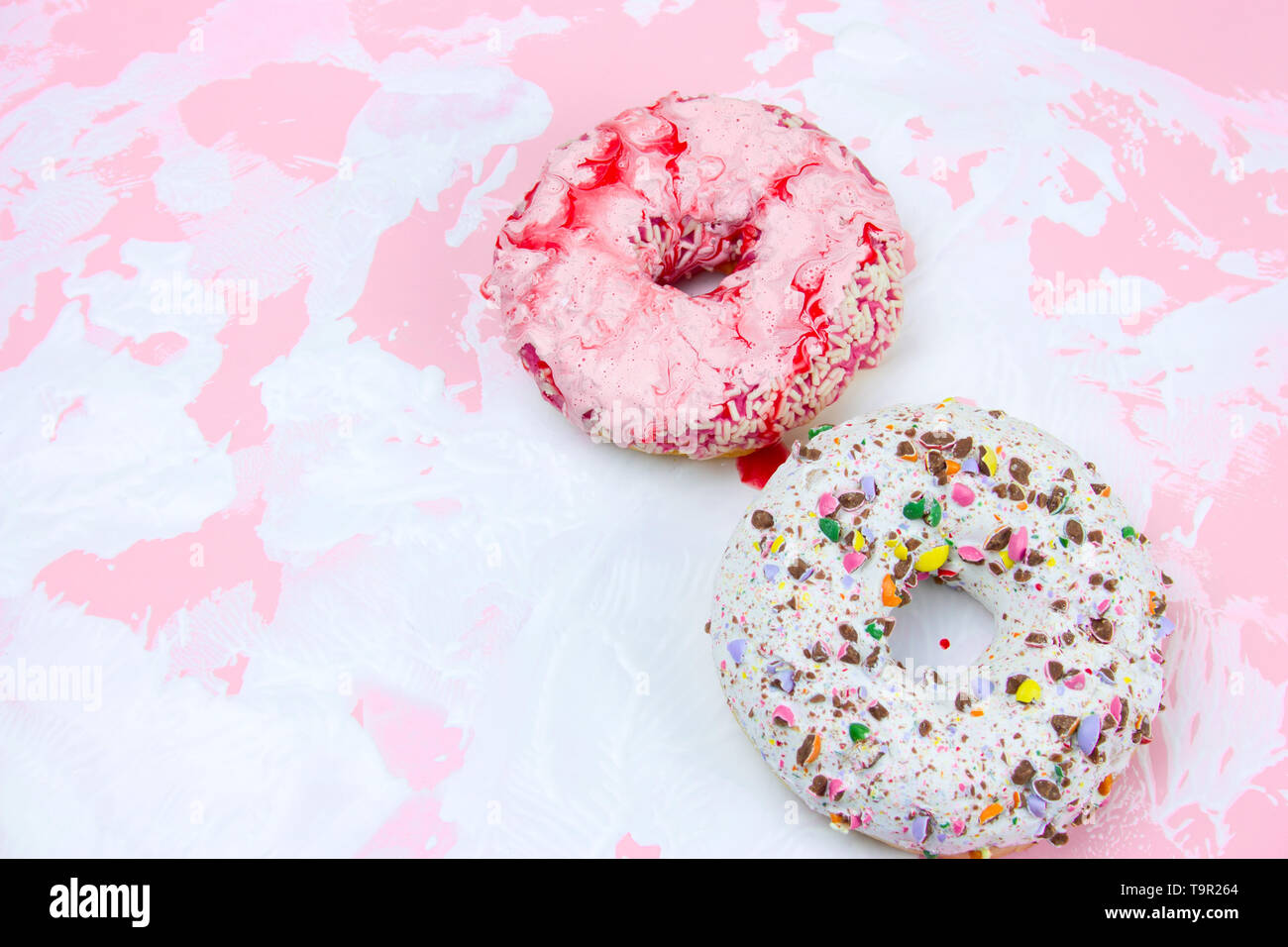 Buñuelos dulces sobre un fondo blanco y rosado. Foto de stock