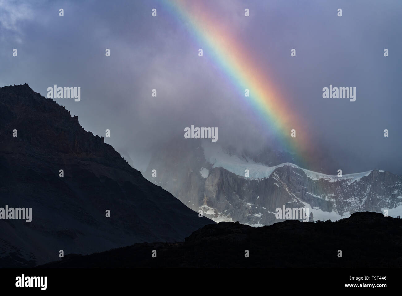 Un arco iris en las nubes enshrouding Monte Fitz Roy en el Parque Nacional Los Glaciares, cerca de El Chaltén, Argentina. Un sitio de Patrimonio Mundial de la UNESCO en el PAT Foto de stock