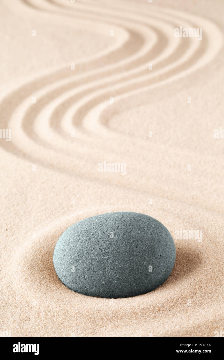 El jardín de meditación de piedra. Concepto de budismo zen japonés y mindfulness. Concepto de concentración y fucusing. Round Rock en el ingenio de fondo arenoso Foto de stock