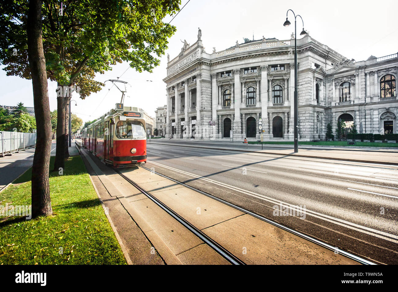 Hermosa vista de la famosa Wiener Ringstrasse con histórico Burgtheater (Teatro de la Corte Imperial) y rojo tradicional tranvía eléctrico al atardecer en Viena Foto de stock