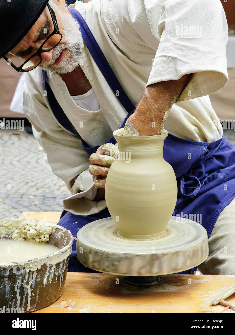 Senior masculino tiradas de Potter una olla de barro sobre su rueda en  Feria Artesanal en Bratislava, mientras que en disfraz Fotografía de stock  - Alamy