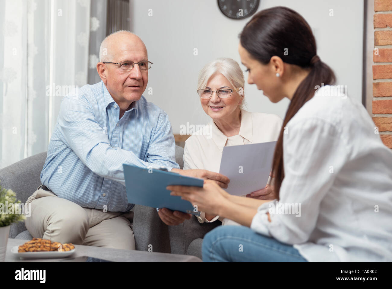 Las parejas ancianas planificar sus inversiones con asesor financiero Foto de stock