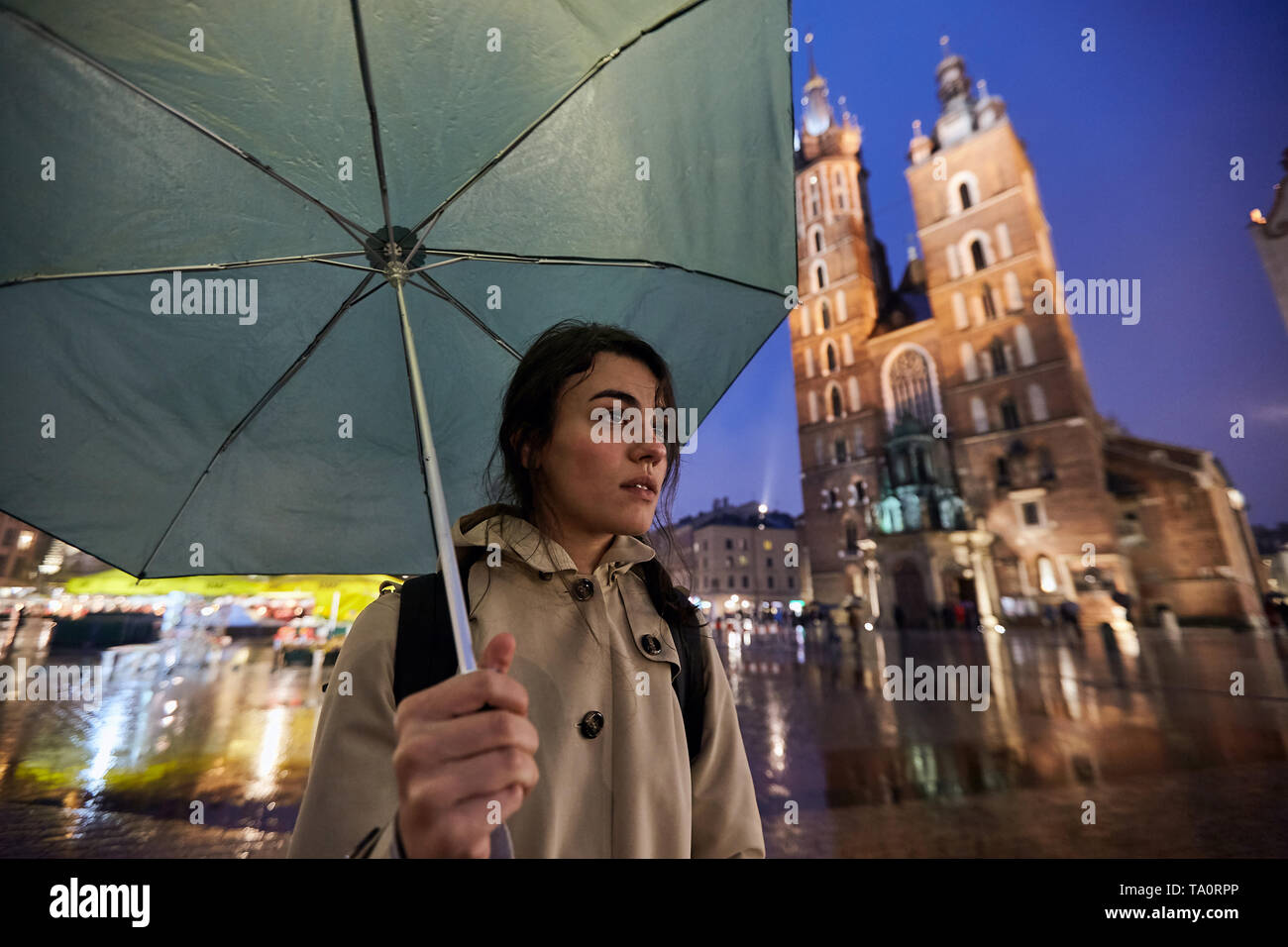 Mujer bajo el paraguas verde en Cracovia (Polonia), lluvias Foto de stock