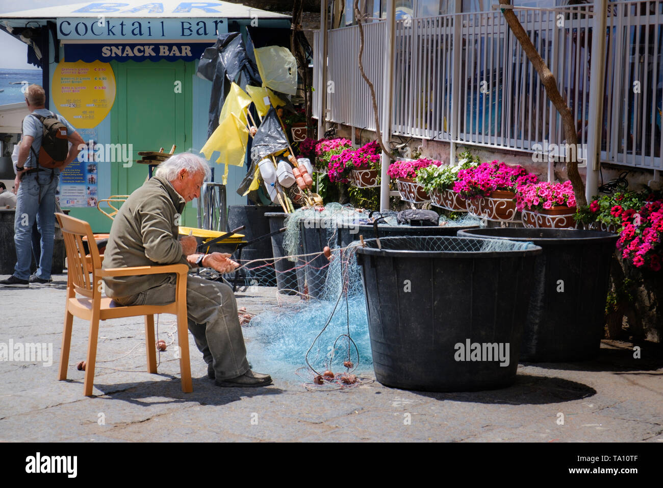 Italiano antiguo pescador arreglando las redes una ocupación tradicional en Positano en la Costa Amalfitana de Campania, en el sur de Italia Foto de stock