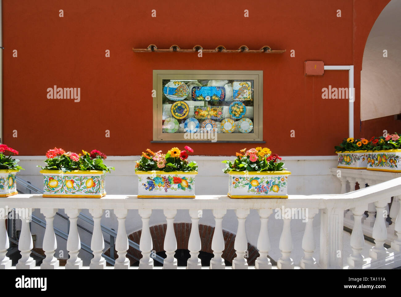 Cerámicas y flores en la pantalla fuera de tienda en Positano, un popular destino de vacaciones y de aldea en la costa de Amalfi, en la región de Campania, Sur de Italia Foto de stock