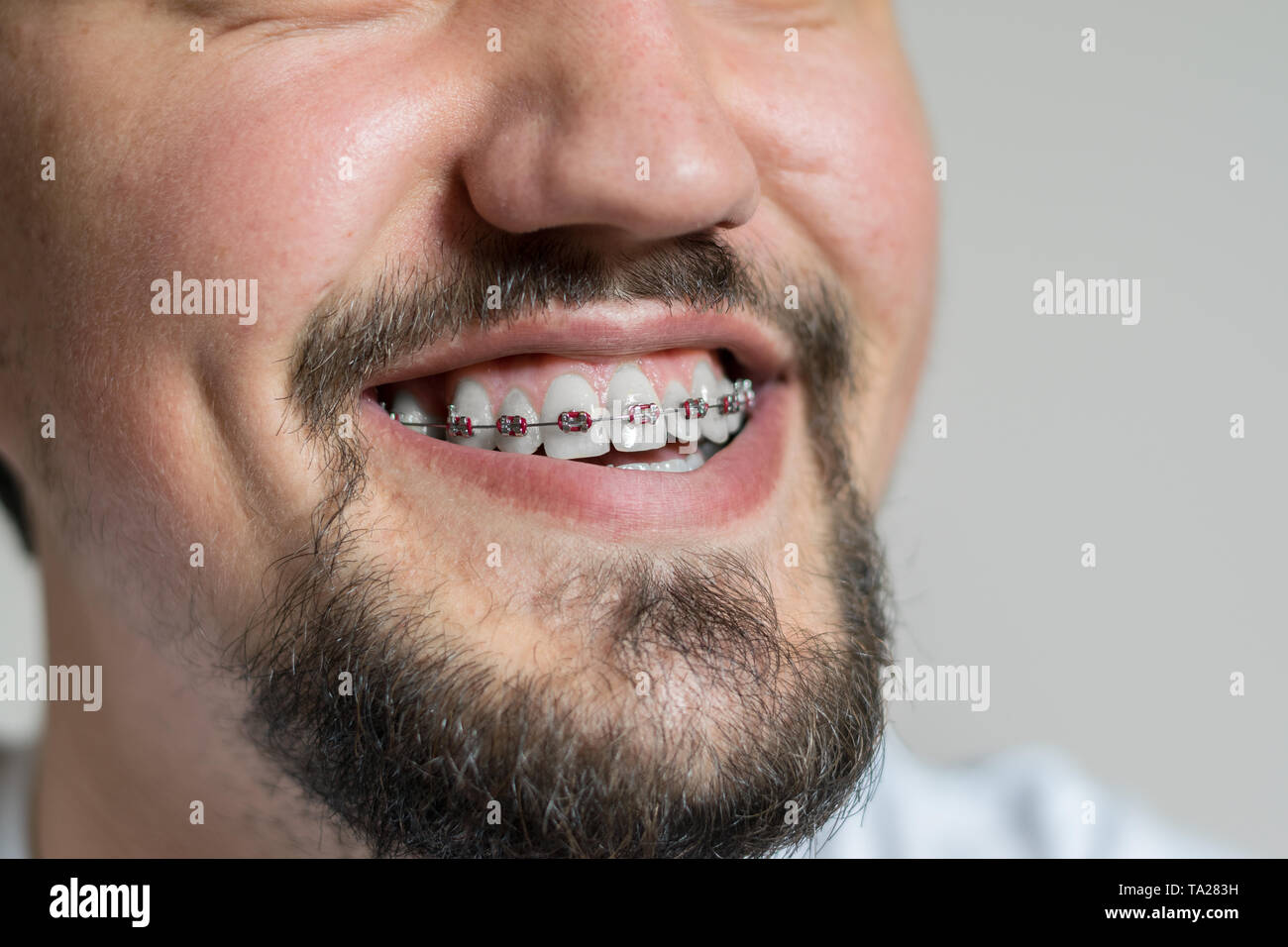 Cerca de un hombre joven con llaves sonriente. Foto de un hombre joven con llaves sobre un fondo blanco. Foto de stock