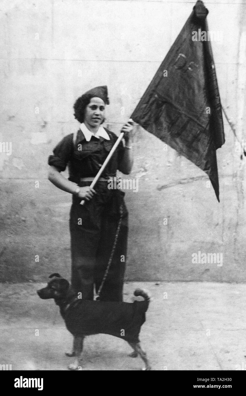 Foto de un anarquista italiano combatiente femenino en Madrid el 24 de septiembre de 1936. La mujer está llevando la bandera negra del batallon de la Muerte (Batallón de la muerte, también llamado Columna o Centuria Malatesta, nombrado después de Errico Malatesta), compuesta de anarquistas italianos, que luchaban en el bando republicano. Ella tiene un perro con una correa. Foto de stock