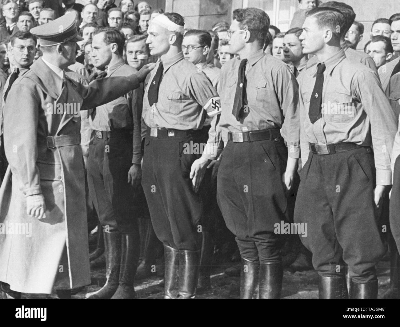 Adolf Hitler en los territorios sudetes, 1938. Él habla a los miembros de las juventudes hitlerianas. Su mano se coloca sobre el hombro de un joven con un vendaje de la cabeza. Foto de stock