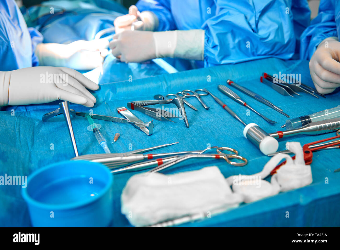 Cerca del doctor manos durante la cirugía en sala de operaciones. La  cirugía estéril instrumentos utilizados en una operación real. El foco está  en la fila de la abrazadera manijas Fotografía de