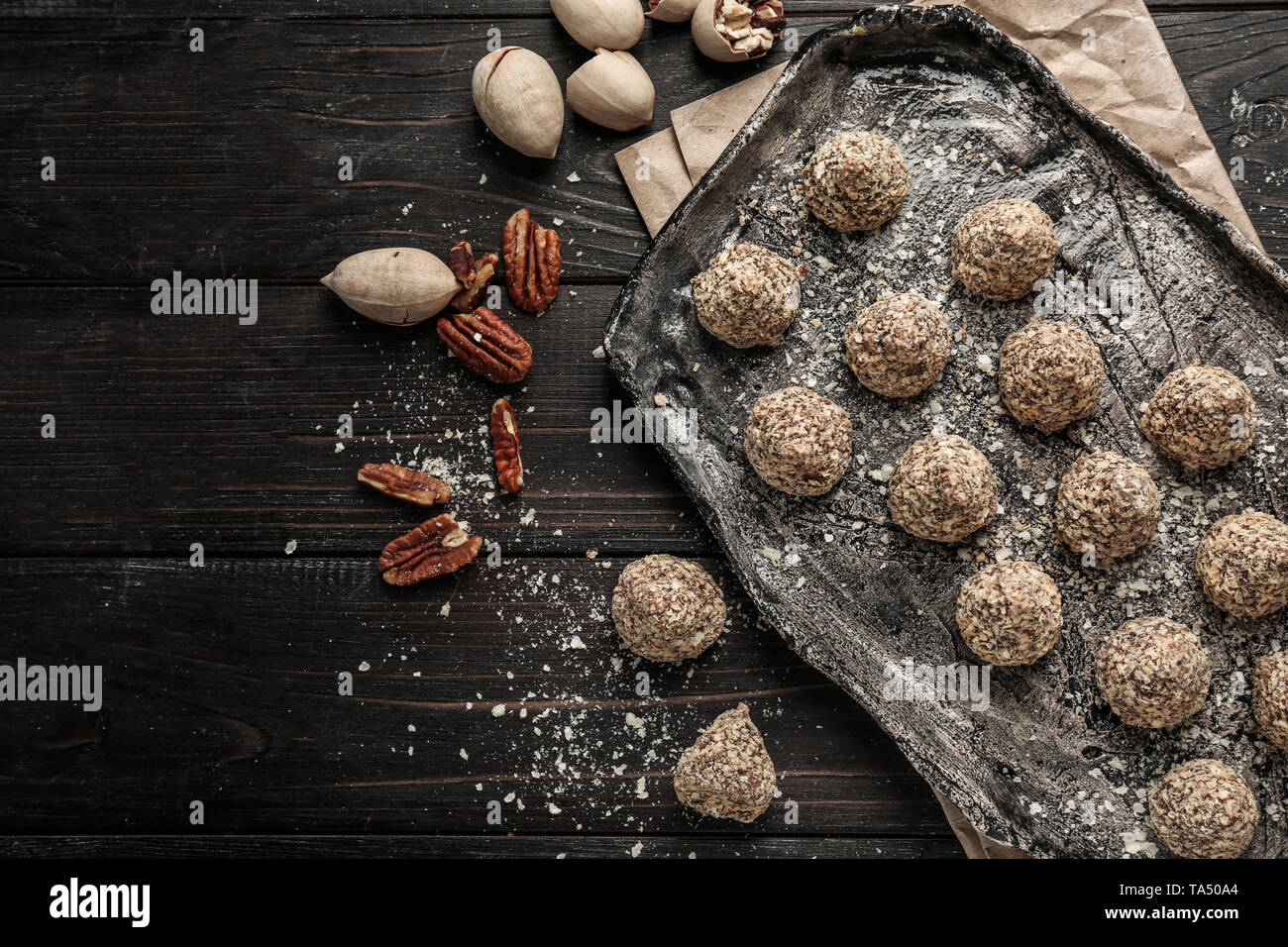 Placa con sabrosos dulces trufas en mesa de madera oscura Foto de stock