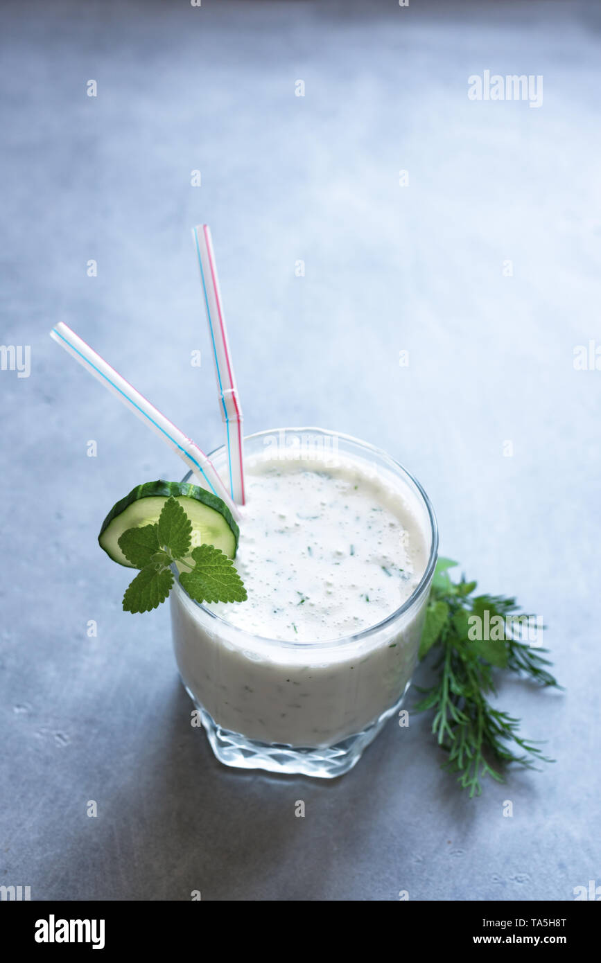 Ayran, yogur casero bebida (kéfir, lassi) con hierbas y pepinos - verano saludable refrescante bebida fría, copie el espacio. Foto de stock