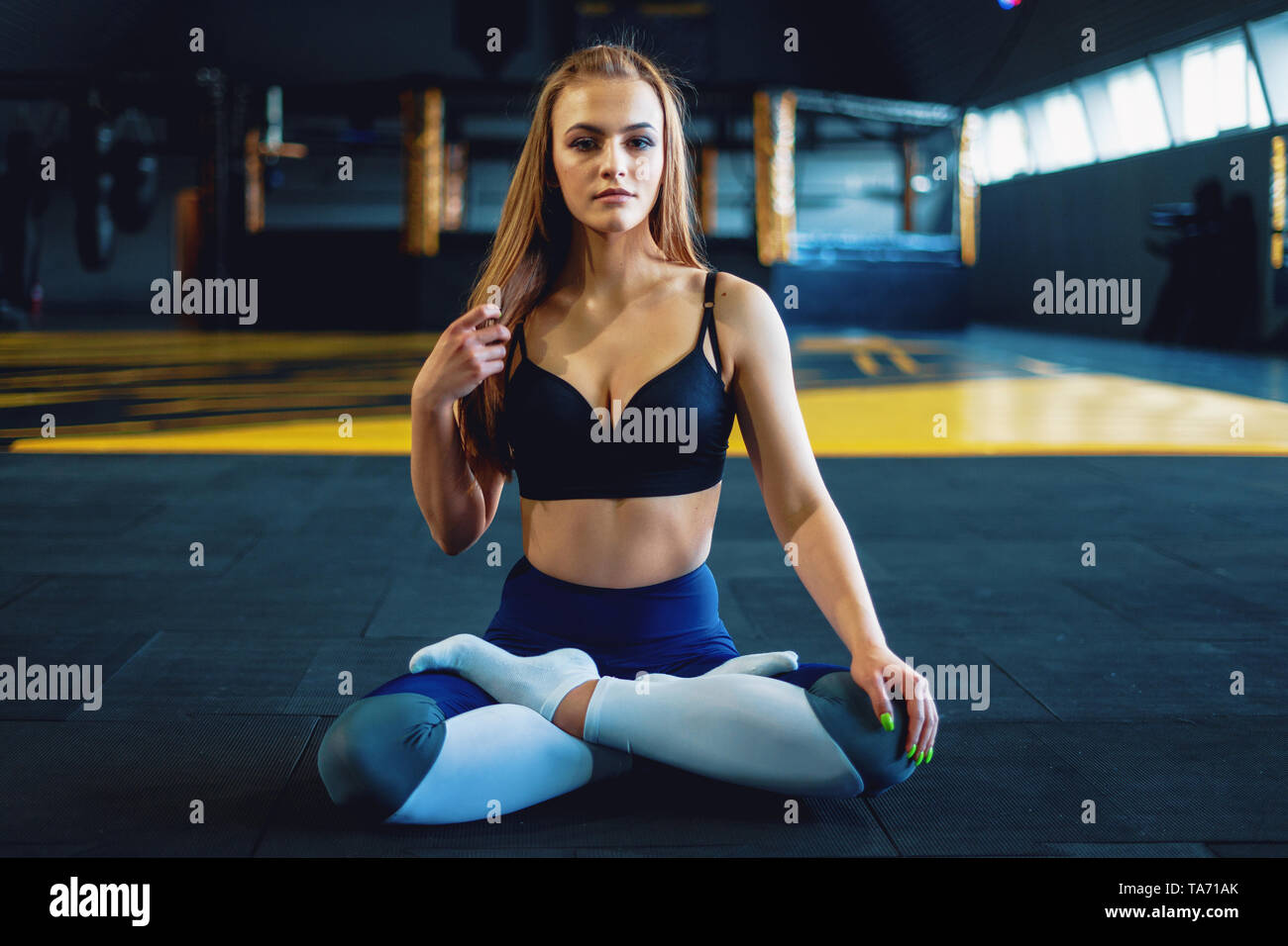 Estirando el gimnasta chica hacer yoga exersizes. Vista del atractivo joven haciendo lotus plantean Foto de stock