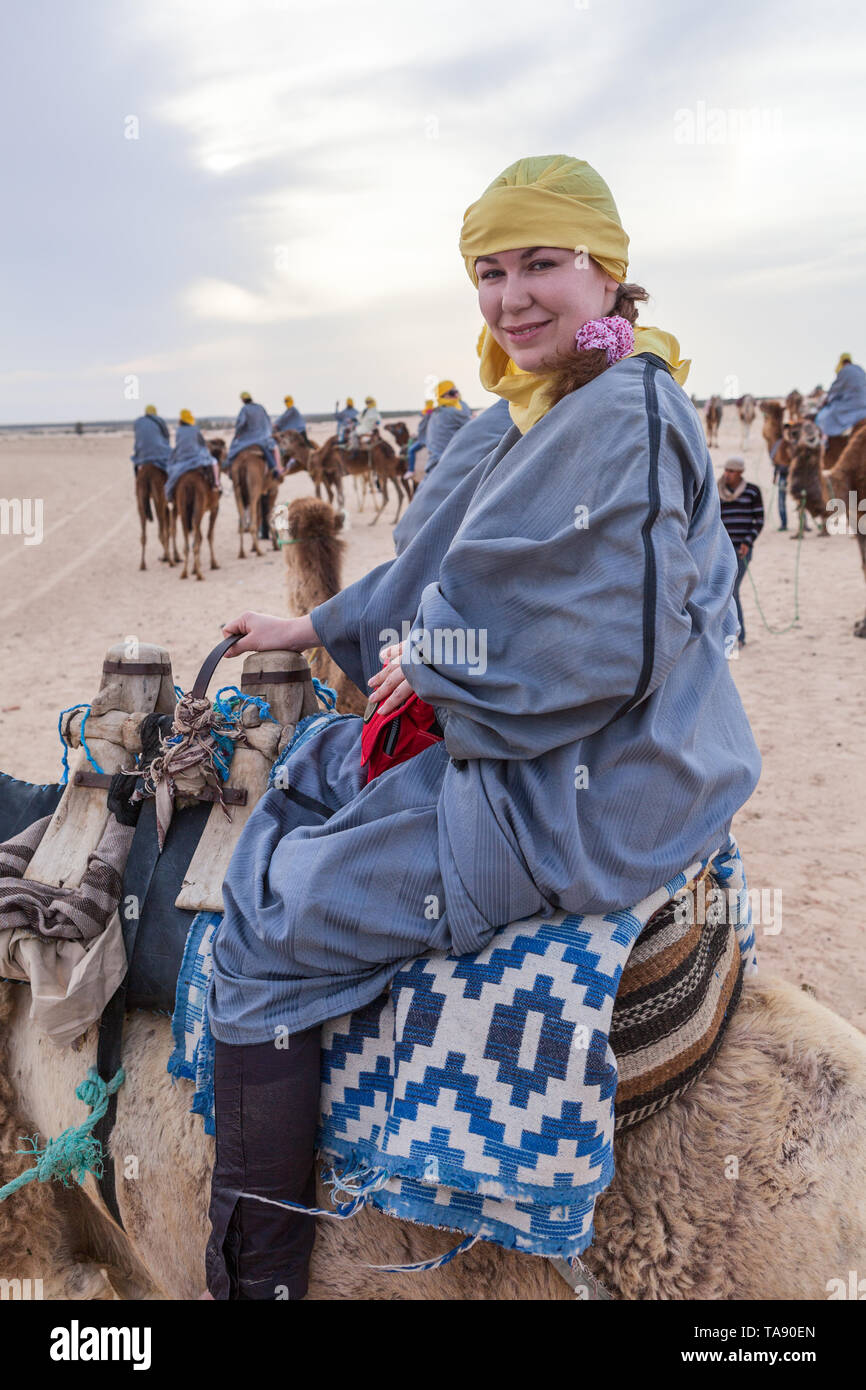 Mujer europea vestidos largos vestidos protectores de arena y velo  sentándose en el camello mientras viajan en el desierto del Sahara en  Túnez, África Fotografía de stock - Alamy