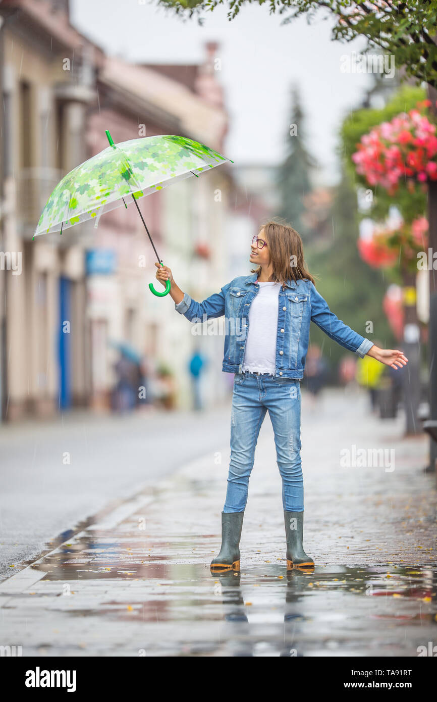 Ajustarse Aislar Rodeo Retrato de joven y bella chica de pre-adolescentes con paraguas bajo la  lluvia de primavera o verano Fotografía de stock - Alamy