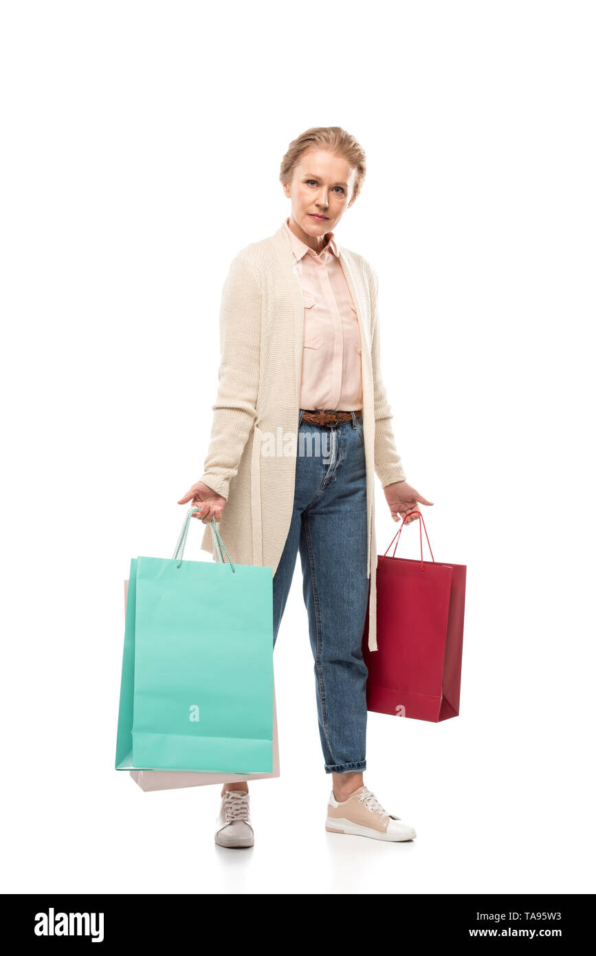 Mujer de mediana edad con bolsas mirando a la cámara en blanco Foto de stock
