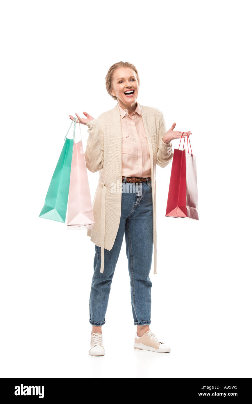 Sonriente mujer de mediana edad con bolsas de compras aisladas sobre blanco Foto de stock