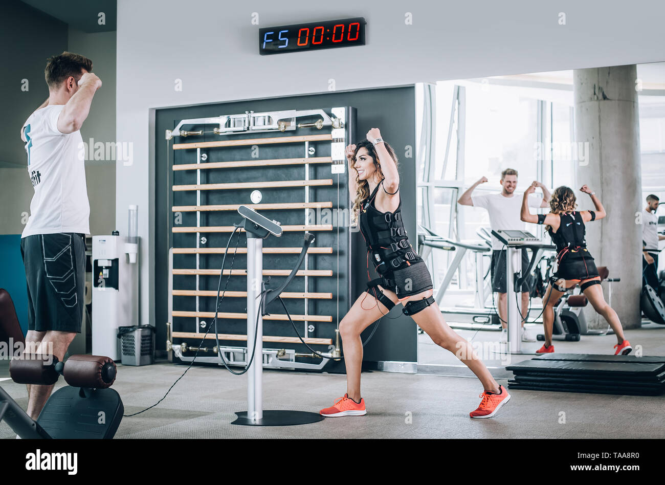 EMS electro estimulación mujeres ejercicios con entrenador en el gimnasio  moderno. Electroestimulación muscular entrenar Fotografía de stock - Alamy