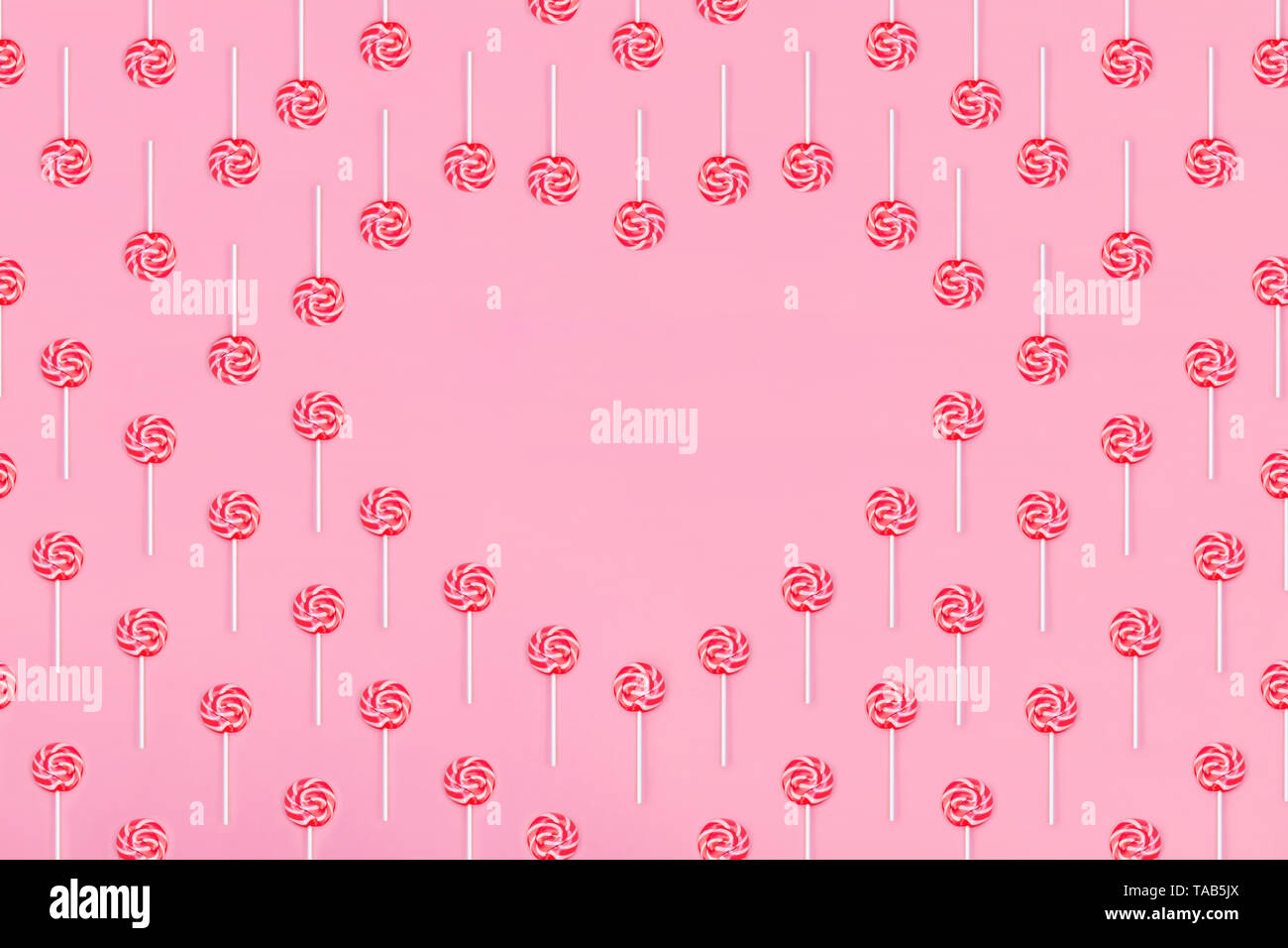 Corazón de piruleta caramelos sobre fondo de color rosa, copie el espacio. Concepto de infancia dulce. Tarjeta de felicitación el día de San Valentín Foto de stock