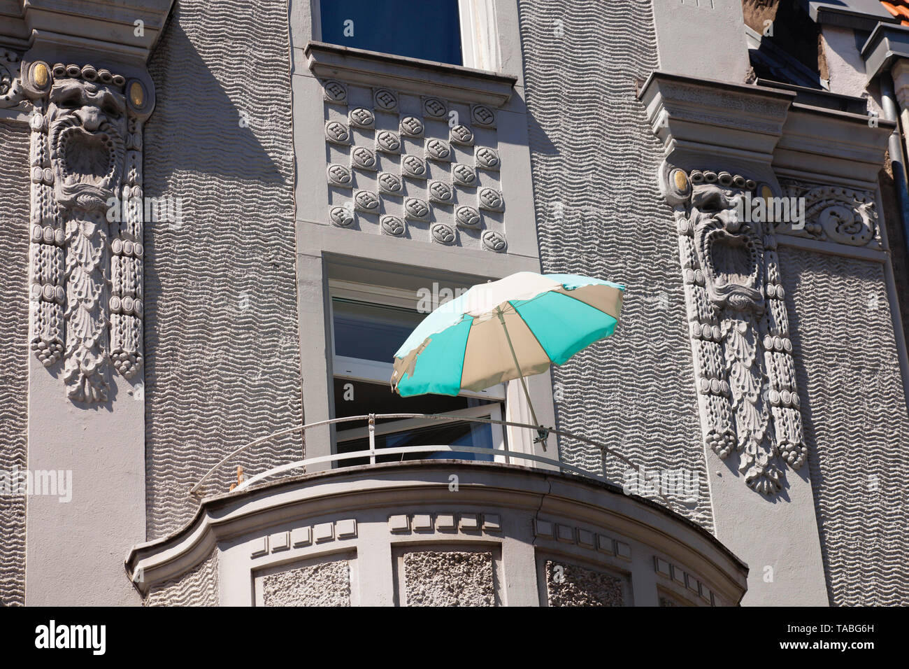La sombrilla en un balcón sobre el Ewaldistreet en el distrito de Agnes, en Colonia, Alemania. Sonnenschirm auf einem Balkon in der Ewaldistrasse Agnesviertel im Foto de stock