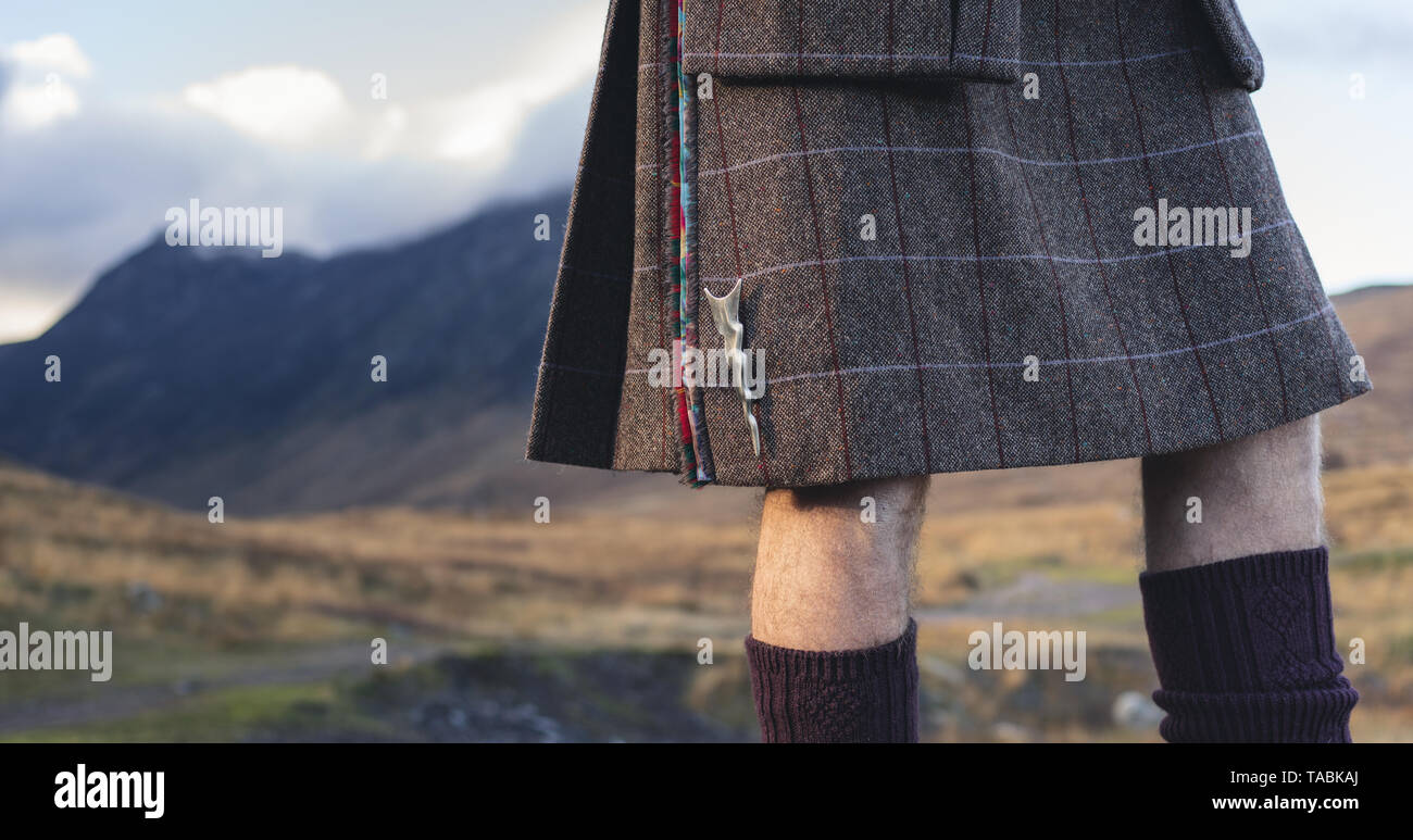 Cuerpo medio la foto de un hombre en una falda escocesa con el telón de fondo de la campiña. Foto de stock
