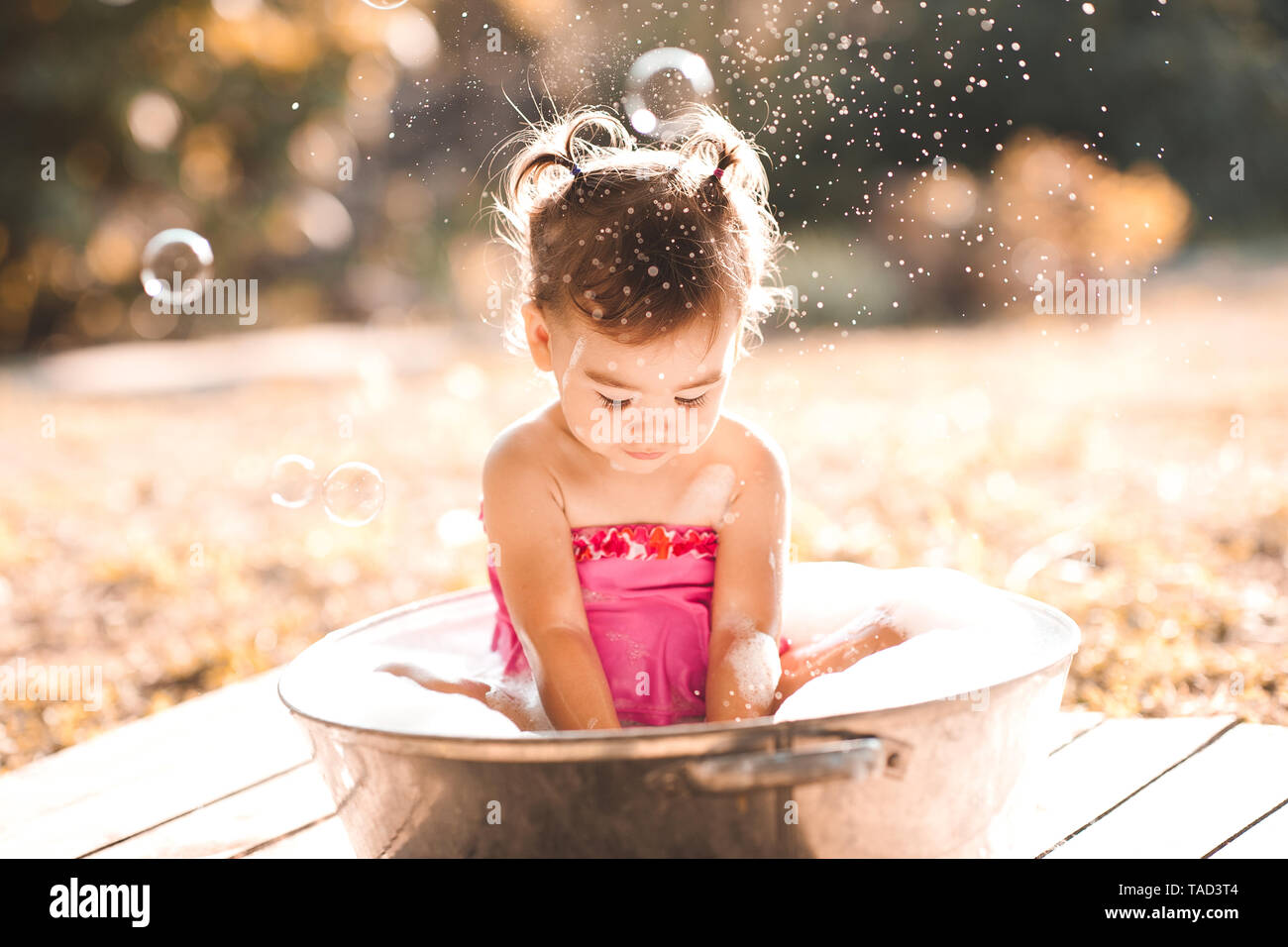 Baby Girl lavado en Cuenca con espuma de jabón en el exterior. La infancia  Fotografía de stock - Alamy