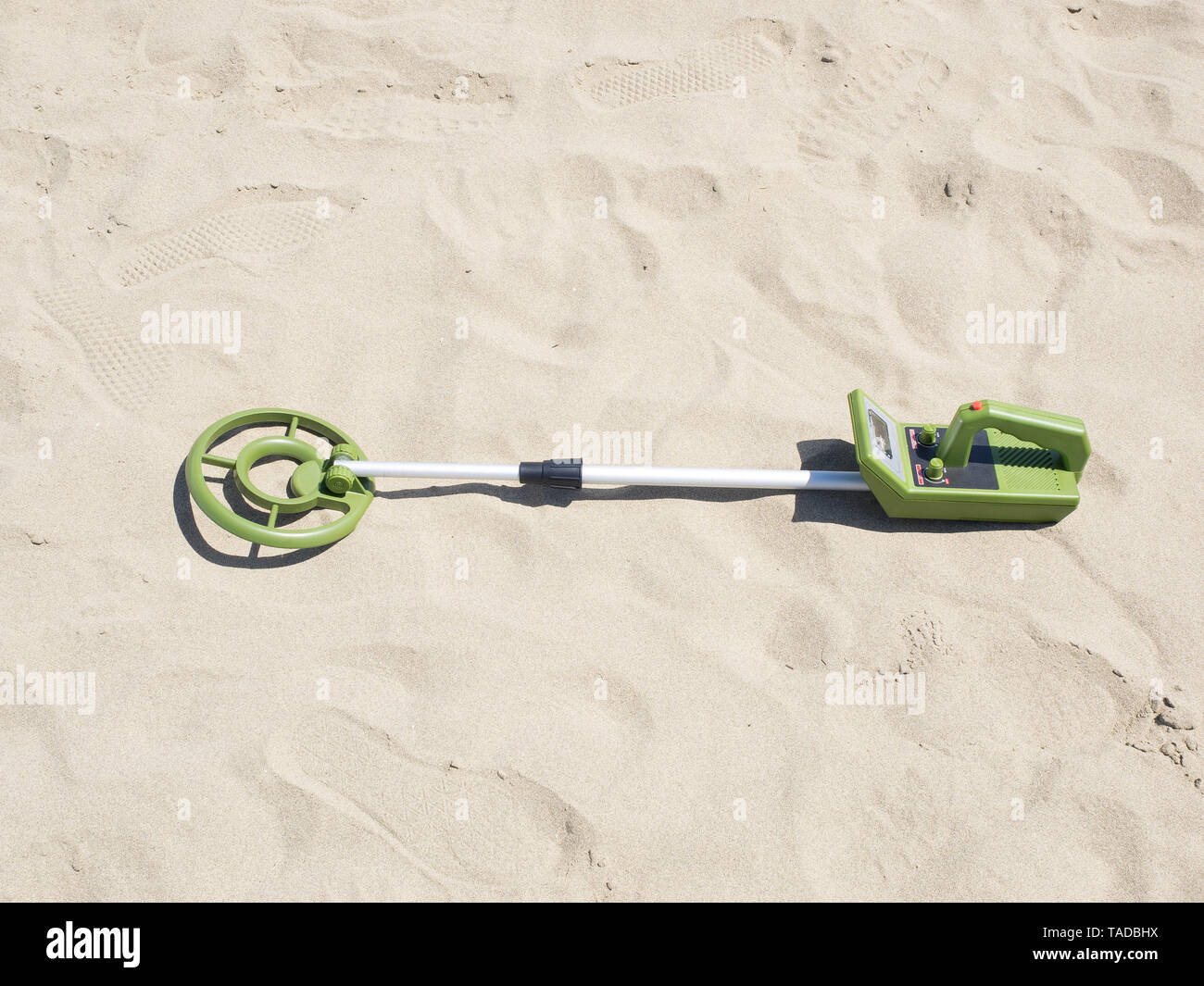 Juguete verde detector de metales en una playa de arena fina está listo  para buscar tesoros Fotografía de stock - Alamy