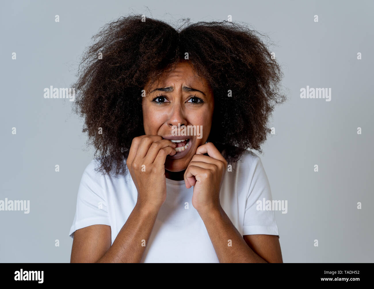 Retrato de joven mujer afroamericana sentirse asustado y consternado el miedo, la ansiedad haciendo gestos. Mirando aterrorizado cubriendo a sí misma. Copie el espacio. En Foto de stock