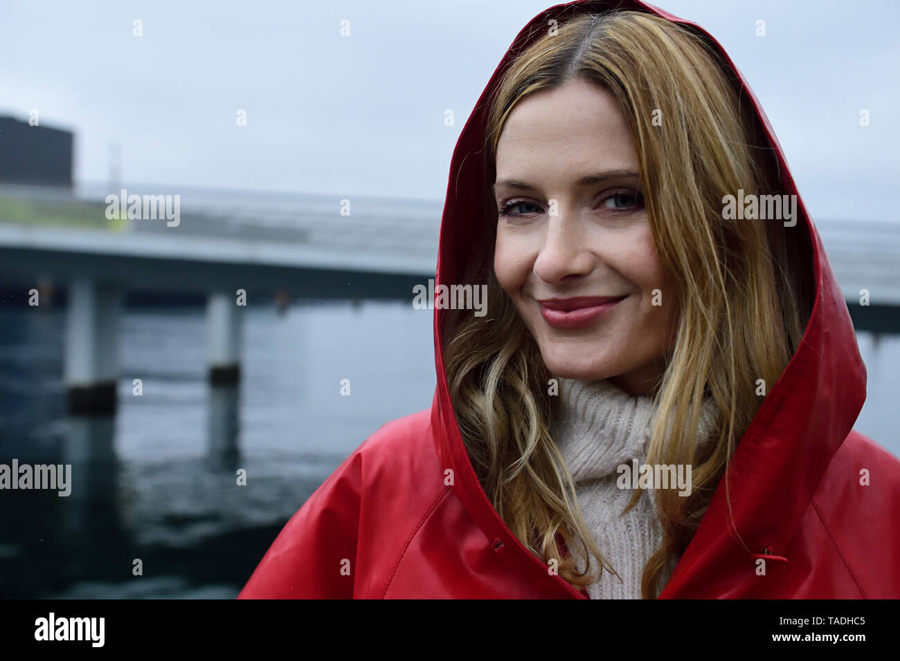 Dinamarca, Copenhague, retrato de mujer sonriente en la Costanera en un día lluvioso Foto de stock