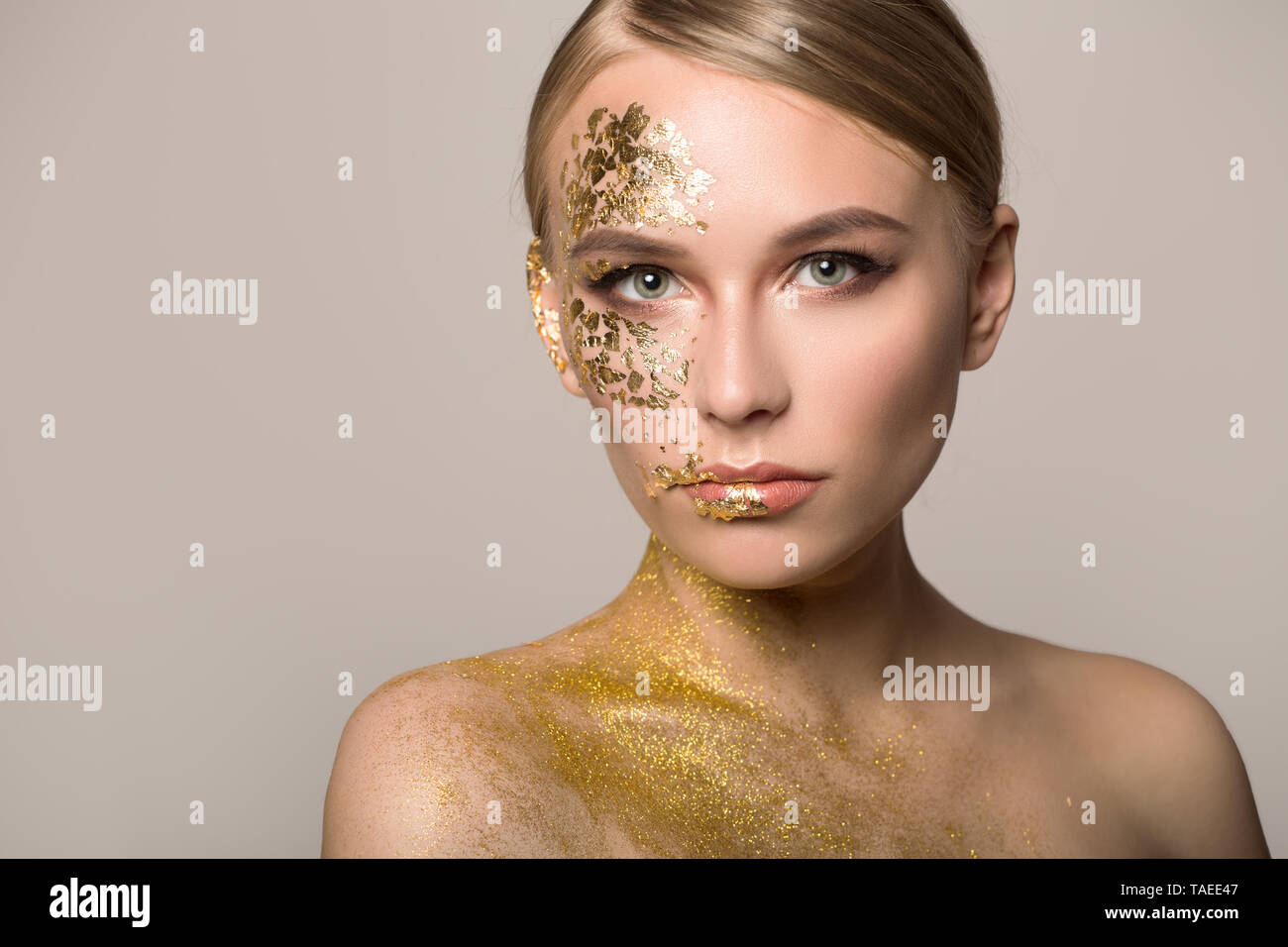 Primer plano de una hermosa chica con máscara de oro cosmético en la piel suave. Foto de stock