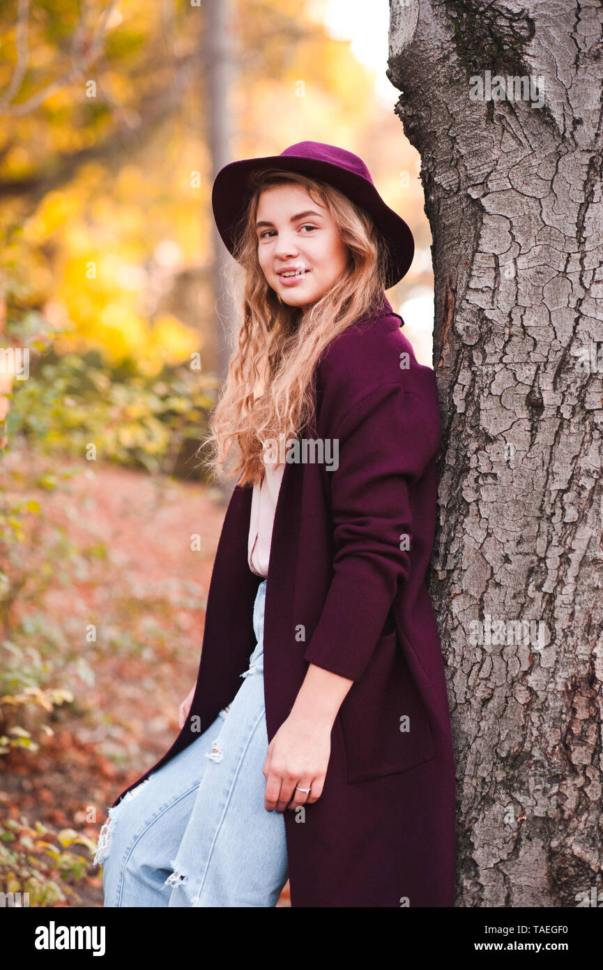 Hermosa rubia jovencita 14-16 años vistiendo Chaqueta elegante sombrero de  fieltro ant apoyándose en árbol en el parque.mirando a la cámara. La  temporada de otoño Fotografía de stock - Alamy