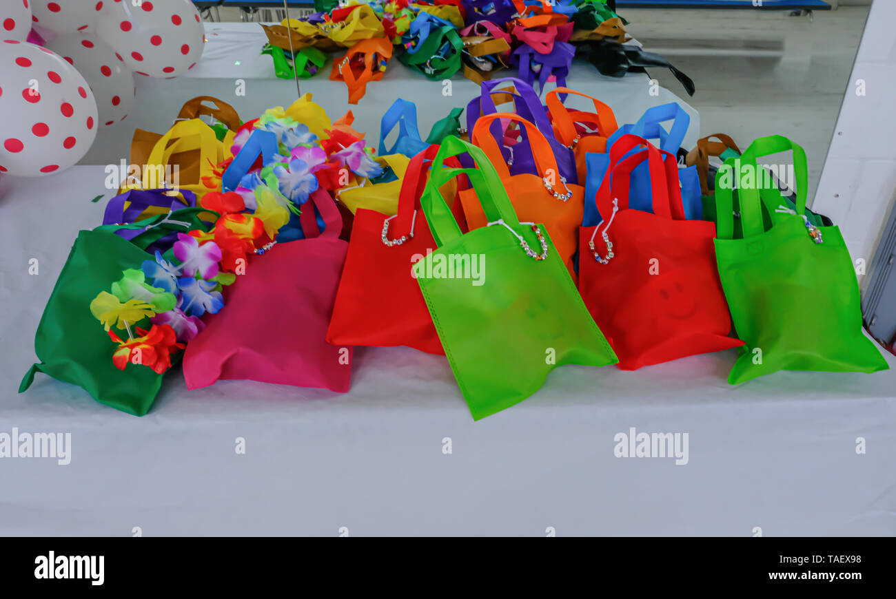 Selección de bolsas de fiesta infantil, preparadas y dispuestas sobre un fondo blanco. Montones de colores vibrantes en estas bolsas de regalos. Foto de stock