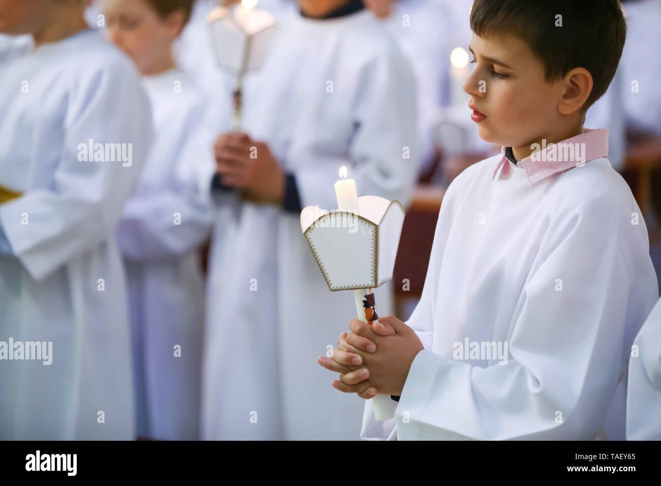 Zagreb, Croacia - Mayo 11, 2019 : un joven niño Sosteniendo velas encendidas durante su primera comunión eucarística en la Iglesia de San en Zagreb, Fotografía de stock Alamy