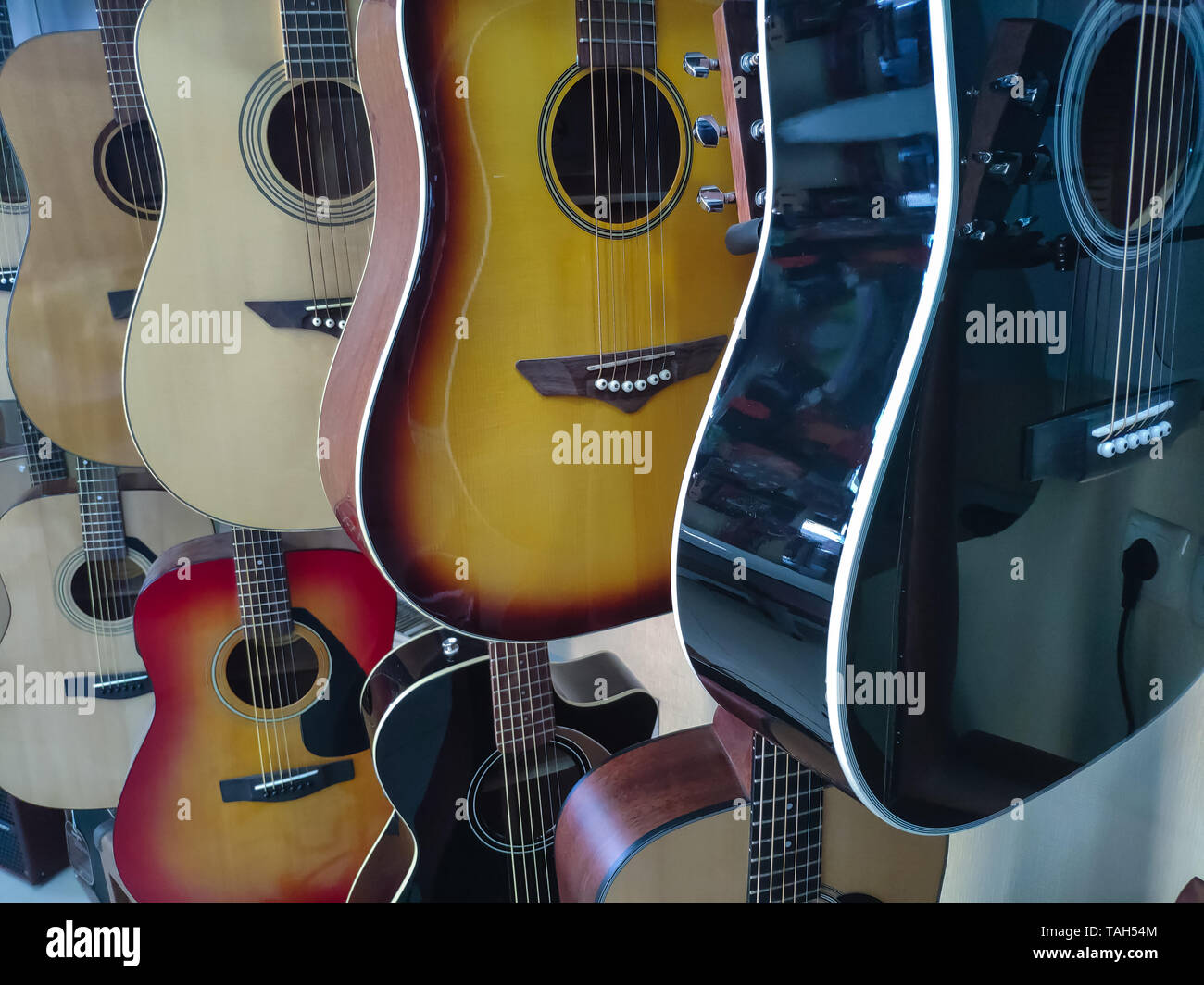 Cerca de una gran variedad de guitarras acústicas de madera en una tienda  de instrumentos musicales, antecedentes o concepto acerca de la música, el  enfoque selectivo Fotografía de stock - Alamy