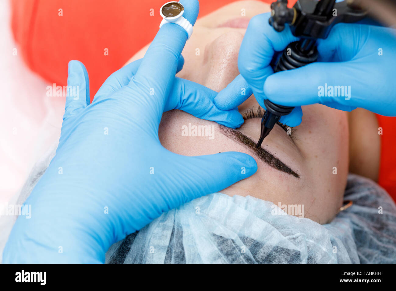 Maquillaje permanente, tatuajes de cejas. Cosmetóloga aplicando componen  con máquina para la mujer en el salón de belleza Fotografía de stock - Alamy